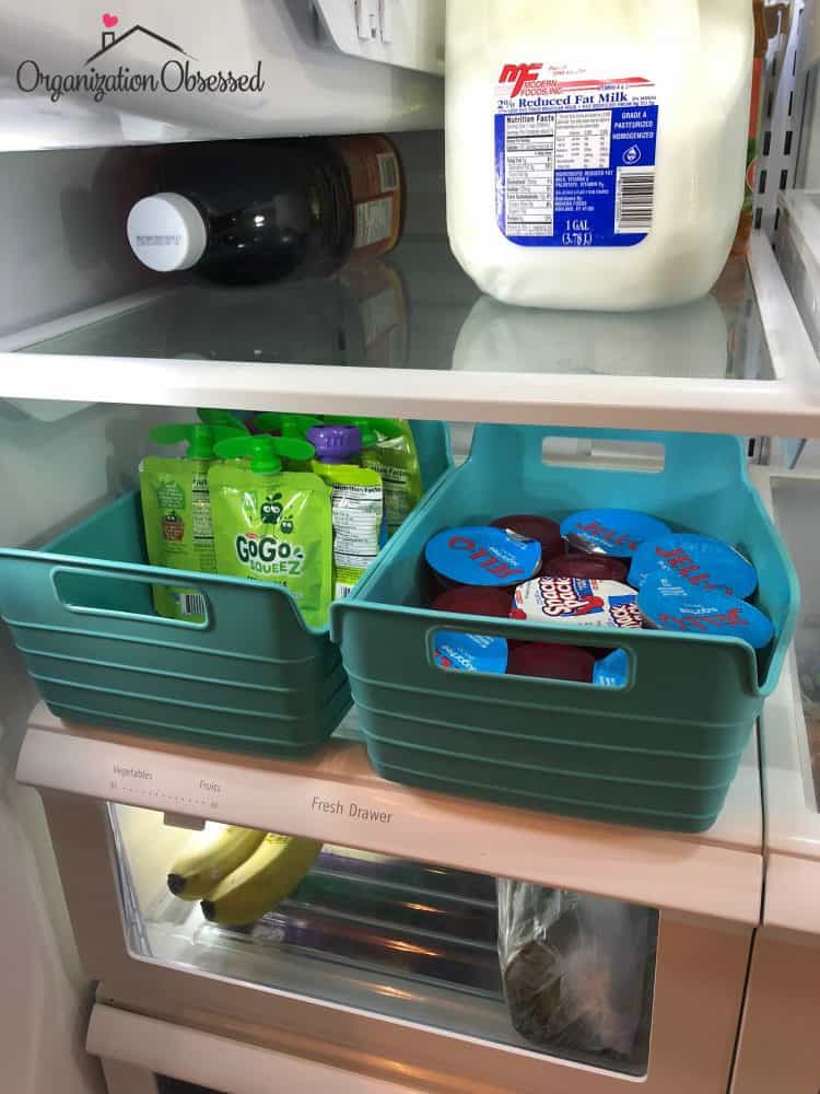 Well-organized refrigerator with various food items stored in clear containers and neatly arranged on shelves.
